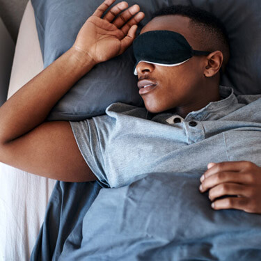 Man asleep with eye mask