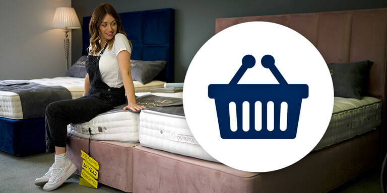 Woman sitting on new mattress in bed showroom